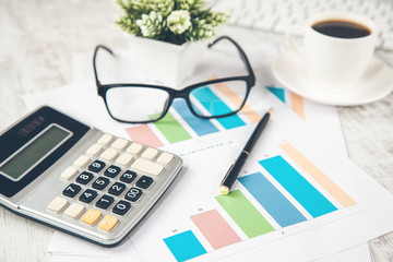 calculator with glasses on graph with  keyboard on desk