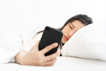 Blur Woman woke up by smartphone alarm clock and turning off snoozing phone alarm clock