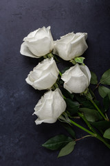 White rose flowers bouquet on black stone background