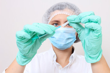 Female doctor in medical mask ready to make injection