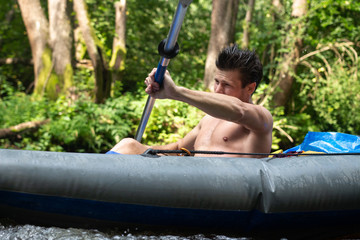 River rafting. Man rowing paddle in kayak.