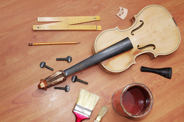 Violin prepared for restoration. Violin and hand tools on a wooden table