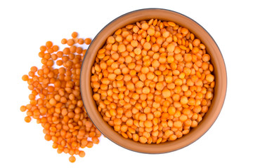 Red lentils in plate isolated on white background