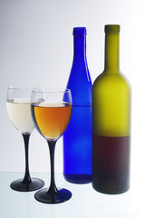 Two glasses of wine and two bottles on a light
