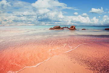 Schöner Strand von Elafonissi auf Kreta, Griechenland. Rosa Sand, blaues Meerwasser und Wolkenhimmel