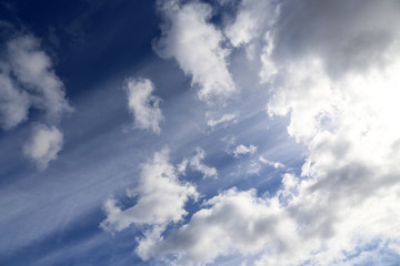 Sky covered with cumulus clouds after the storm. Spring cloudy sky with sun rays, beautiful background for weather