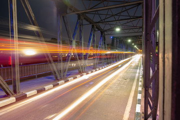 Fototapeta na wymiar motion of head light of the car that drive pass iron bridge in night time