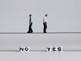 Two miniature men walking into a different direction.