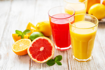 Glasses of juice and citrus fruits