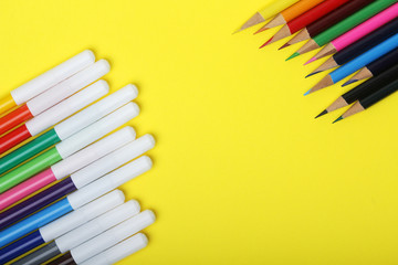 Multicolored markers and pencils at bright background	