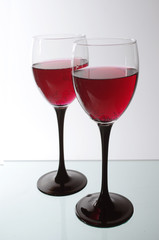 Two glasses of wine on a light background.