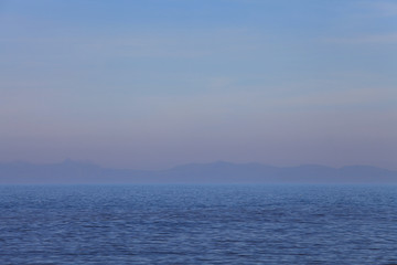 Fototapeta premium Simple seascape of hazy mountains on the horizon