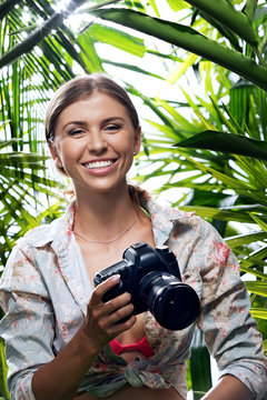 portrait of nice young woman is taking picture in the  jungle