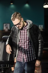 A man posing in a black winter jacket and jeans. Advertise menswear