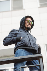 A man posing in a black winter jacket and jeans. Advertise menswear