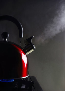 Kettle standing on the stove, steam comes out of the spout