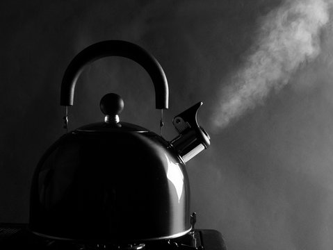 Kettle standing on the stove, steam comes out of the spout