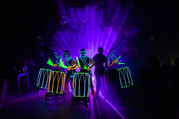 laser show performance, dancers in suits with LED lamp