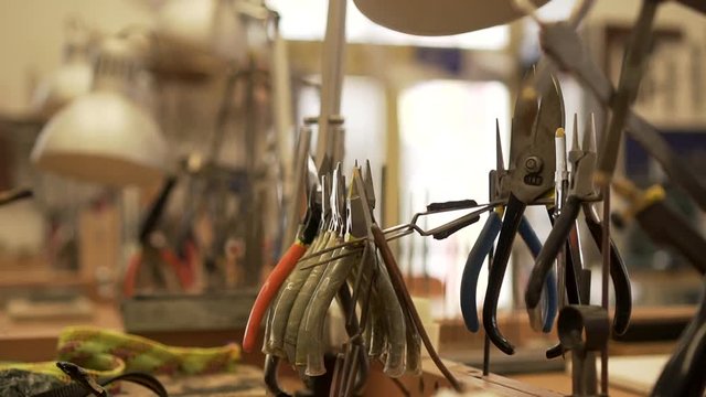 Detail of workroom full of pliers, tweezers, splitters and other tools in slow motion