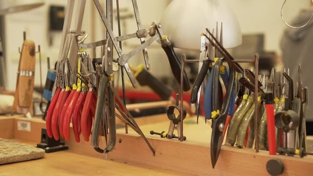 Detail of workroom full of pliers, tweezers, splitters, files and other tools in slow motion