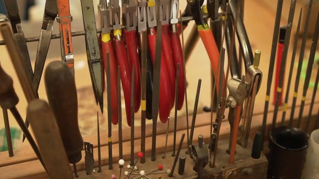 Close-up of files, pliers, tweezers and splitters on the stand in workroom / garage