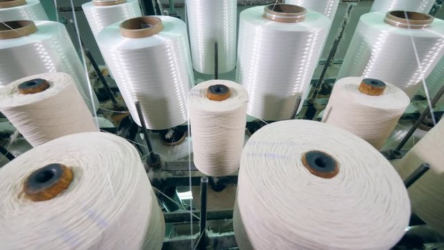 Yarn spools on spinning machines at a textile plant.