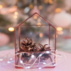  Glass object  house with pinecone inside near christmas tree with lights. Abstract geometric shape of glass.