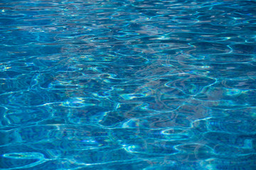 Blurred water texture in summer pool close up.