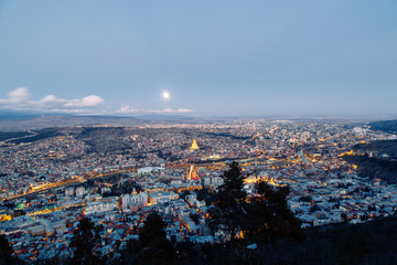 Sunset and evening city Tbilisi, Georgia. Panoramic views and lights of historic neighborhoods.