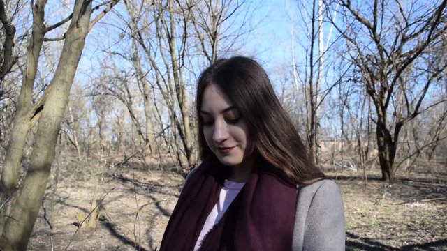 Fashion portrait of a young brunette girl in a dry spring Park.
