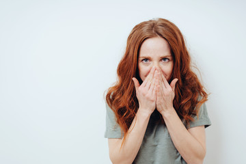 Embarrassed young woman hiding behind her hands
