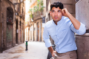 Fototapeta premium young European guy in blue shirt walking around city