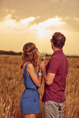 Couple in sunset / sunrise time in a wheat field.