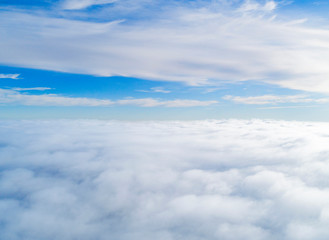 Aerial view White clouds in blue sky. Top view. View from drone. Aerial bird's eye view. Aerial top view cloudscape. Texture of clouds. View from above. Sunrise over clouds