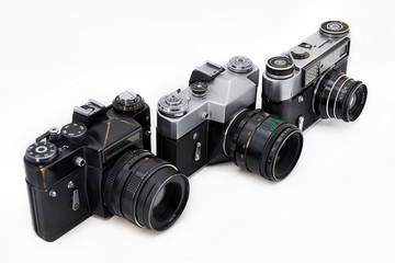 Three old photo cameras isolated on white background