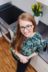 Confident young woman relaxing in her kitchen