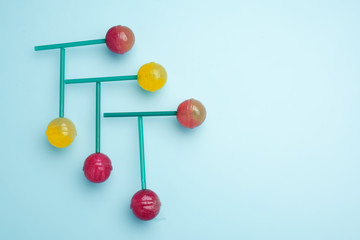 Sweet multicolored lollipop on a stick. Lollipop laid out on the blue table. Copy space for text.