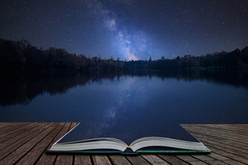 Vibrant Milky Way composite image over landscape of still lake coming out of pages in magical story book - obrazy, fototapety, plakaty