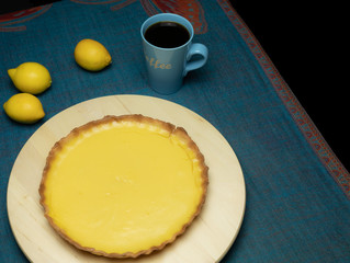 Zitronenkuchen mit gerissener Füllung auf blauem Tischtuch