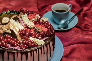 Barry Drip Cake auf rotem Stofftisch mit blauer Kaffetasse