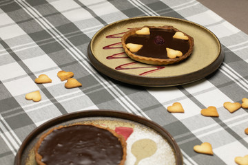 Schokoladen Tartelettes mit Gebäck auf kariertem Tischtuch