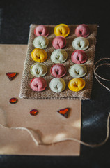 Ravioli of red, yellow and green color on eco rustic fabric