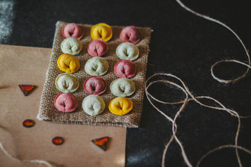 Ravioli of red, yellow and green color on eco rustic fabric