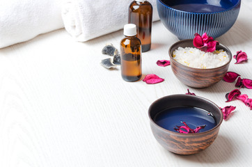 Bowls with cosmetics products,towels,bottles with oil on white surface,cope space. Concept of spa treatments