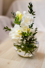Obraz na płótnie Canvas white freesia flowers in a round vase