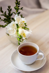 cup of tea and white freesia flower