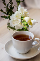 cup of tea and white freesia flower
