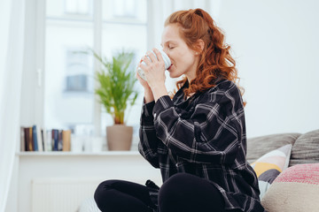 Thirsty young woman drinking from a cup