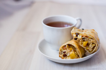 cup of tea and apple strudel on a saucer
