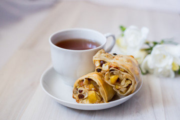 cup of tea, apple strudel pieces, freesia flower